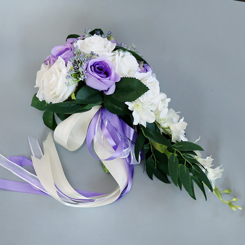 Waterfall-style white flowers bouquet with artificial blooms and purple accents, ideal for maternity events.