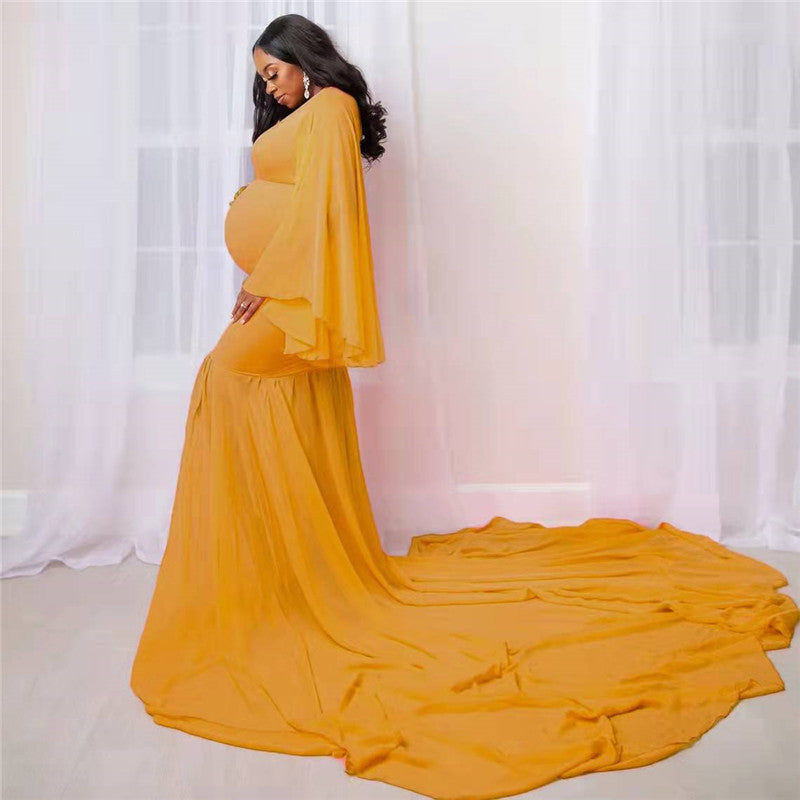 Maternity long flowing dress in solid color with elegant train, ideal for pregnancy photoshoots.